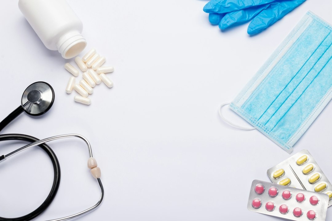 Stethoscope, blood pressure cuff, and reflex hammer on white surface.